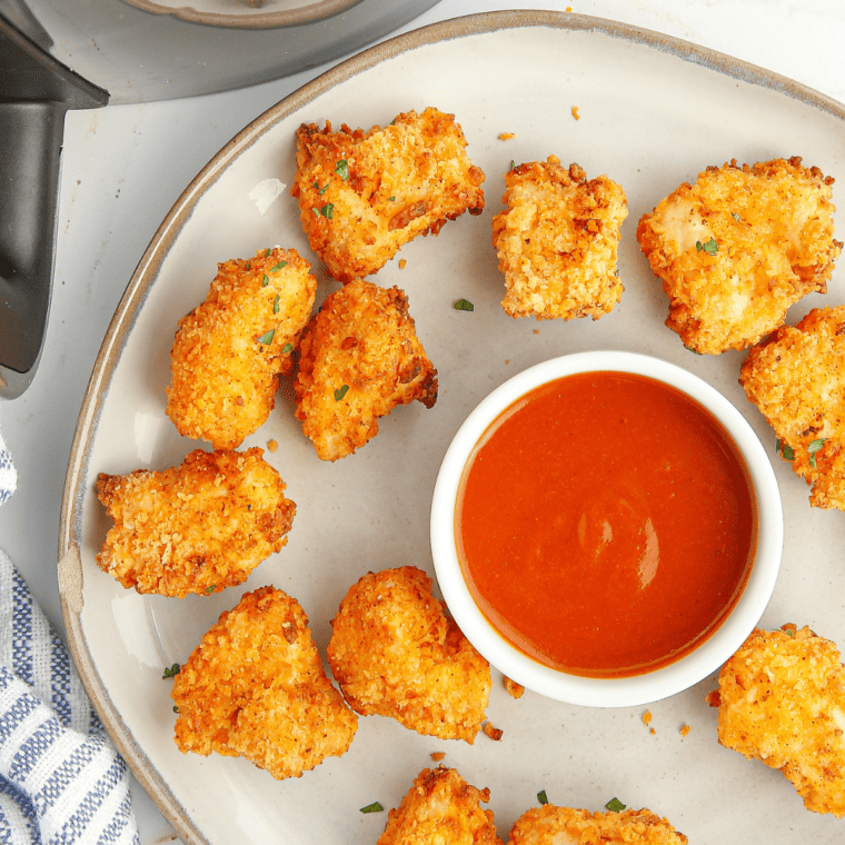 Air fryer basket filled with crispy popcorn chicken bites straight out of cooking