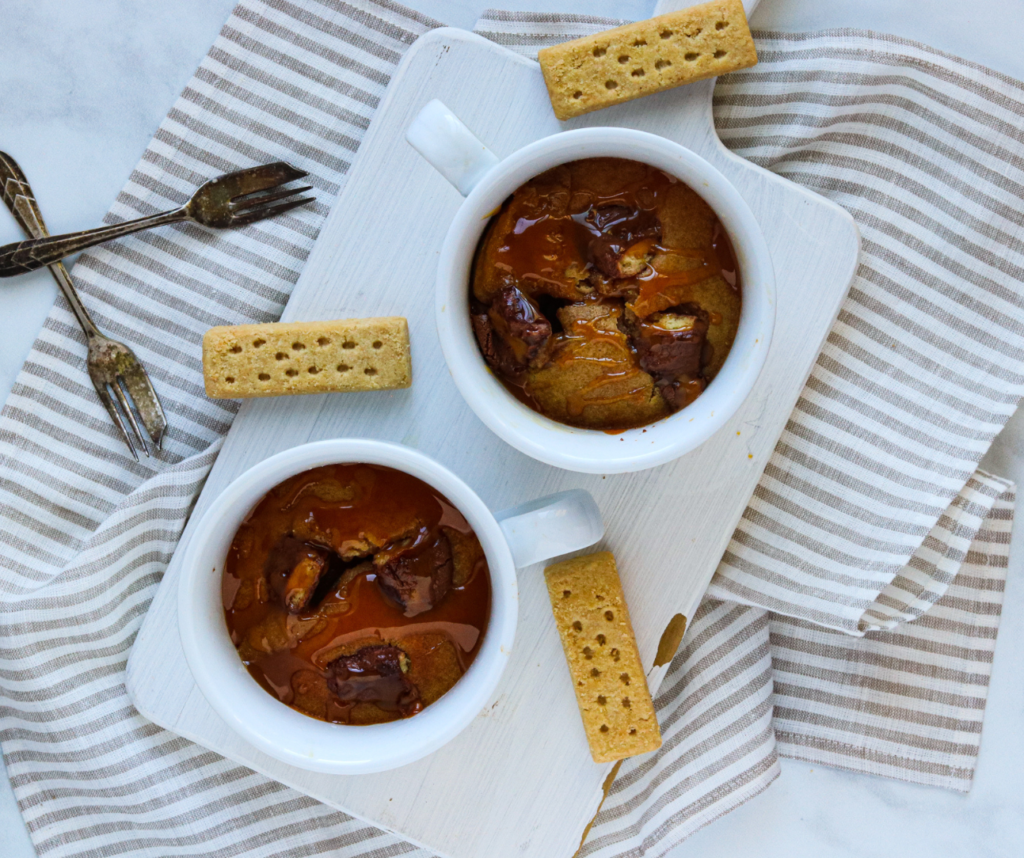 Air Fryer Twix Mug Cake topped with chocolate and caramel drizzle