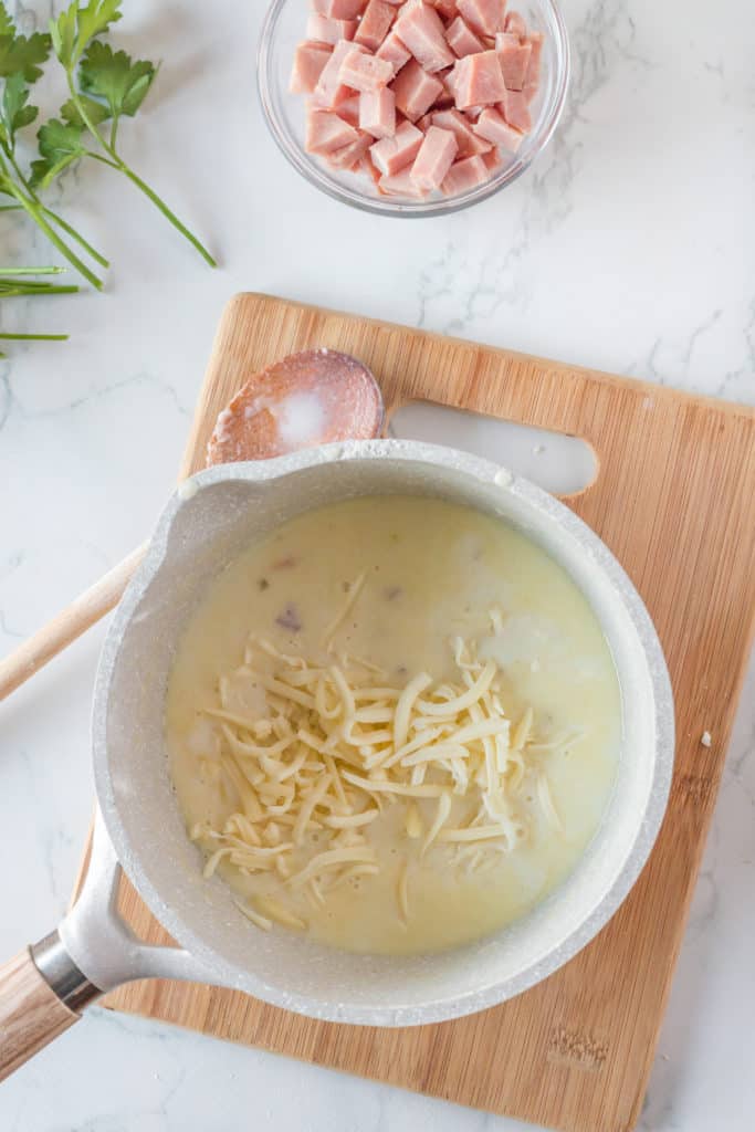 "Cauliflower florets being coated with cheese sauce before air frying."