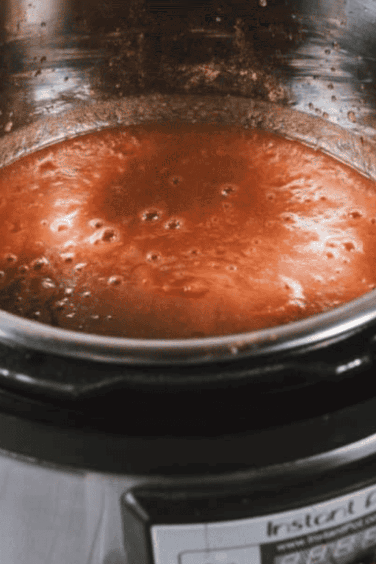 Homemade Cracker Barrel apple butter in instant pot bowl simmering.
