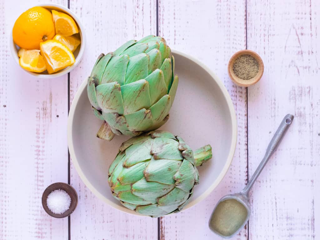 Ingredients for air fryer artichokes: artichokes, olive oil, lemon, garlic, salt, and pepper