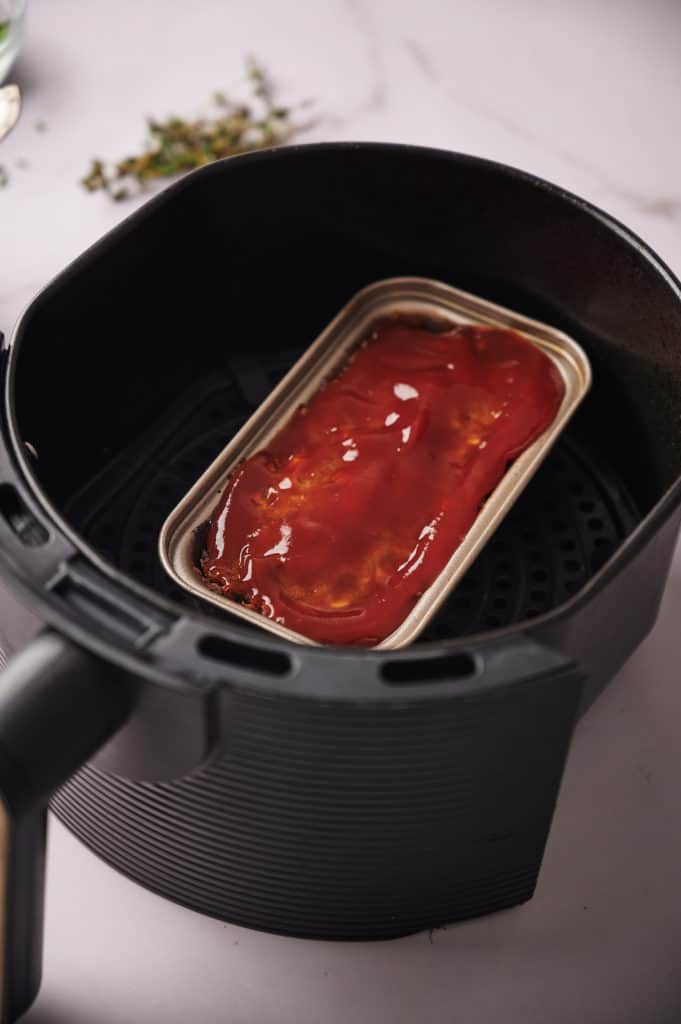 Cooked Air Fryer Meatloaf with Bourbon Glaze in the air fryer basket.