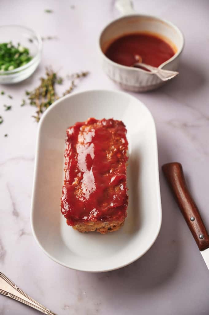Plate of meatloaf with bourbon glaze on kitchen table.