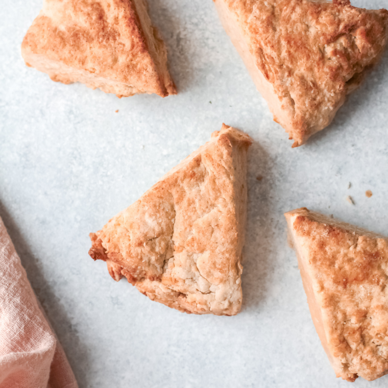 Glazed air fryer apple scones on a plate with visible pieces of diced apple