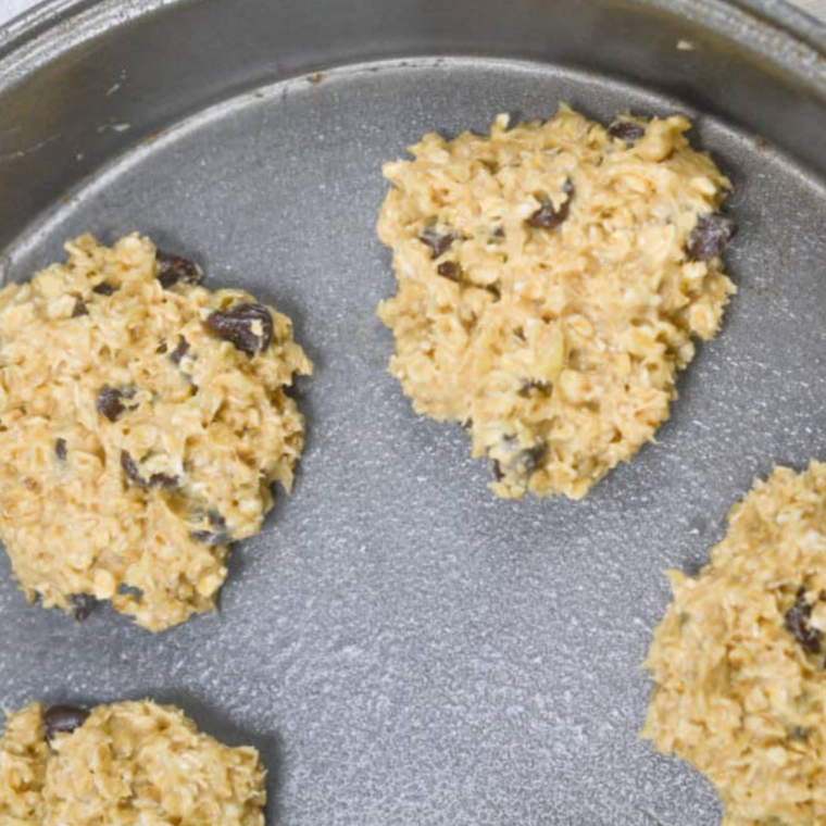 Using a cookie scoop to portion banana cookie dough onto parchment paper