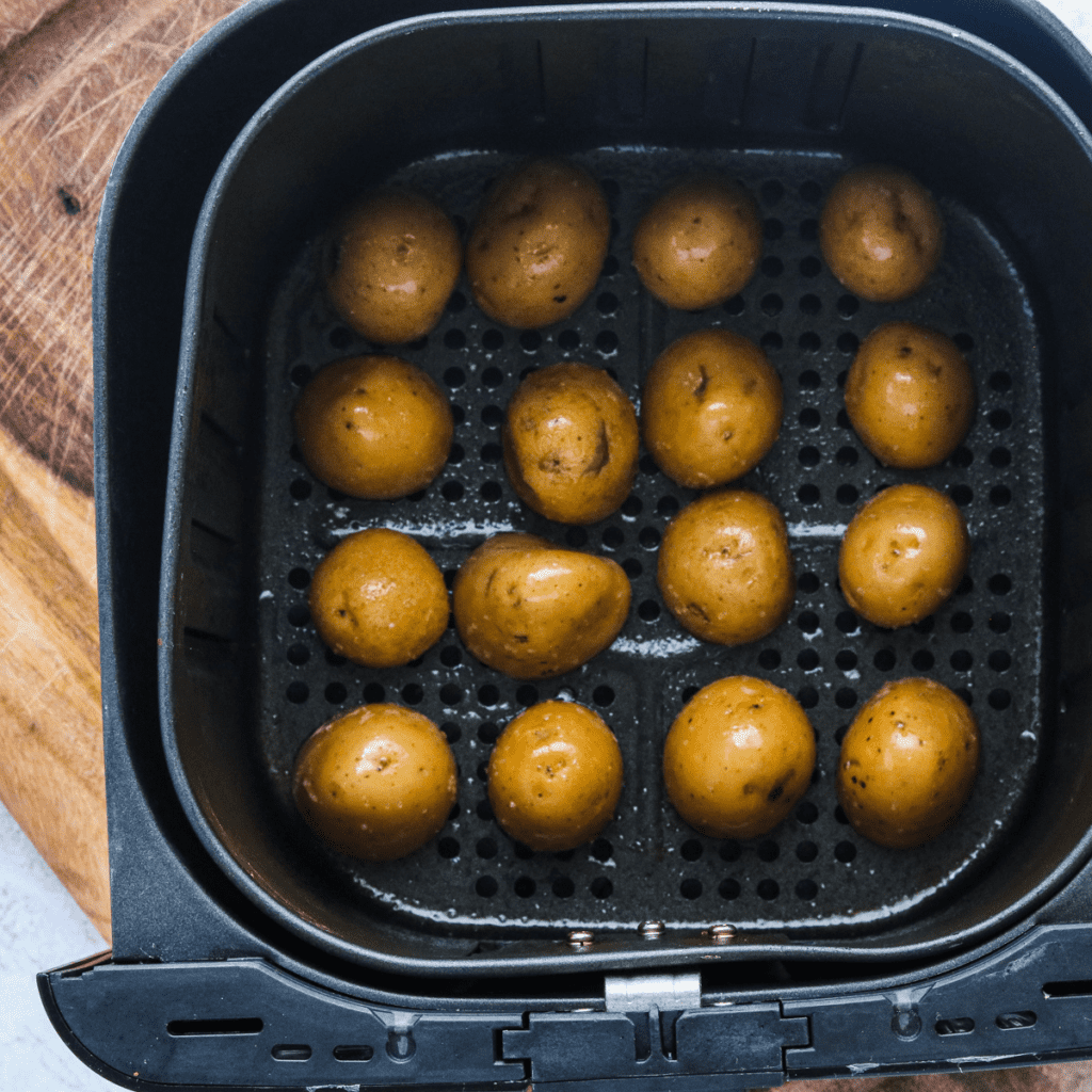 Placing seasoned potatoes in the air fryer basket, cooking at 400°F for 10-12 minutes, and tossing with spice mixture after cooking
