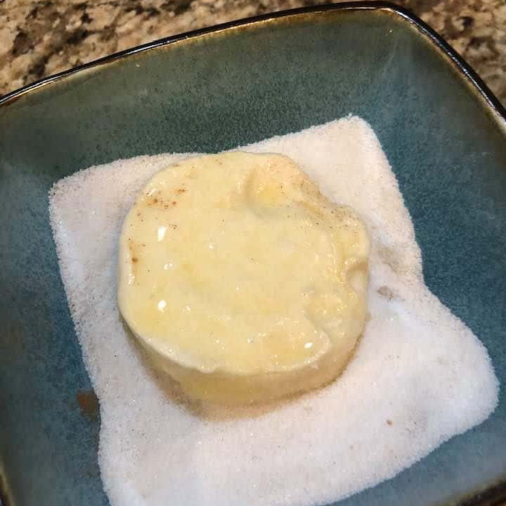 Coating the biscuits with the sugar and butter.