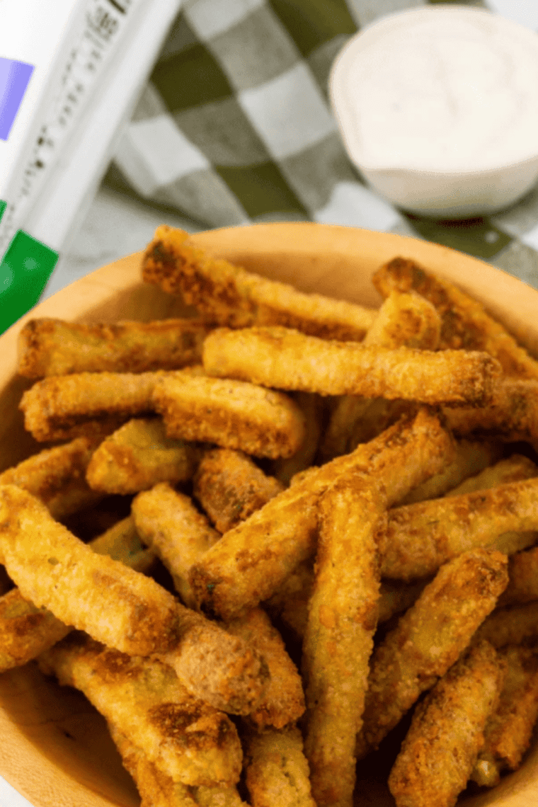Golden, crispy Air Fryer Frozen Zucchini Fries on a plate with dipping sauce.