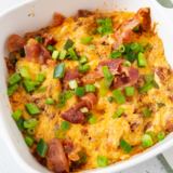 Air fryer jalapeño popper dip in a rustic bowl, creamy and bubbling with melted cheese, topped with sliced jalapeños, crumbled bacon, and scallions