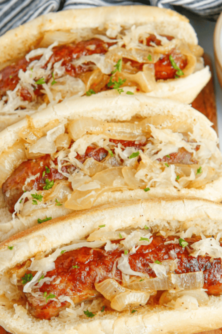 Air fryer hot dogs in buns topped with tangy sauerkraut, cooked until juicy and ready to serve.