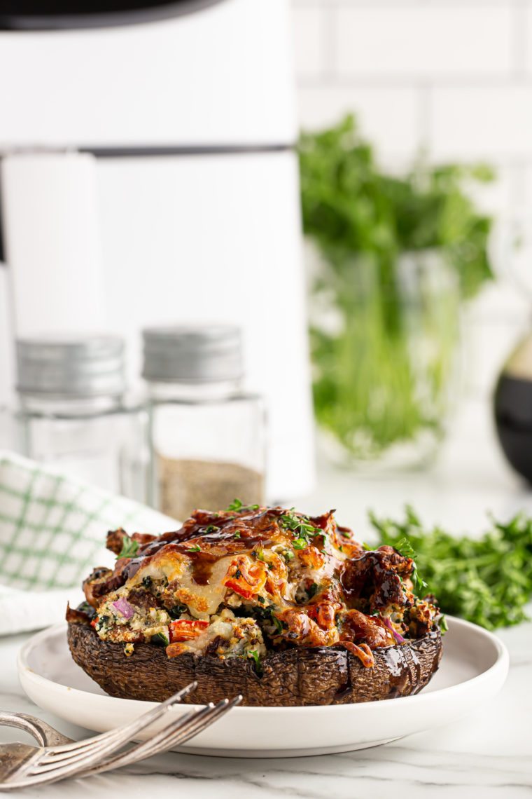 Air fryer stuffed portobello mushrooms filled with breadcrumbs, cheese, and herbs, cooked to golden perfection.