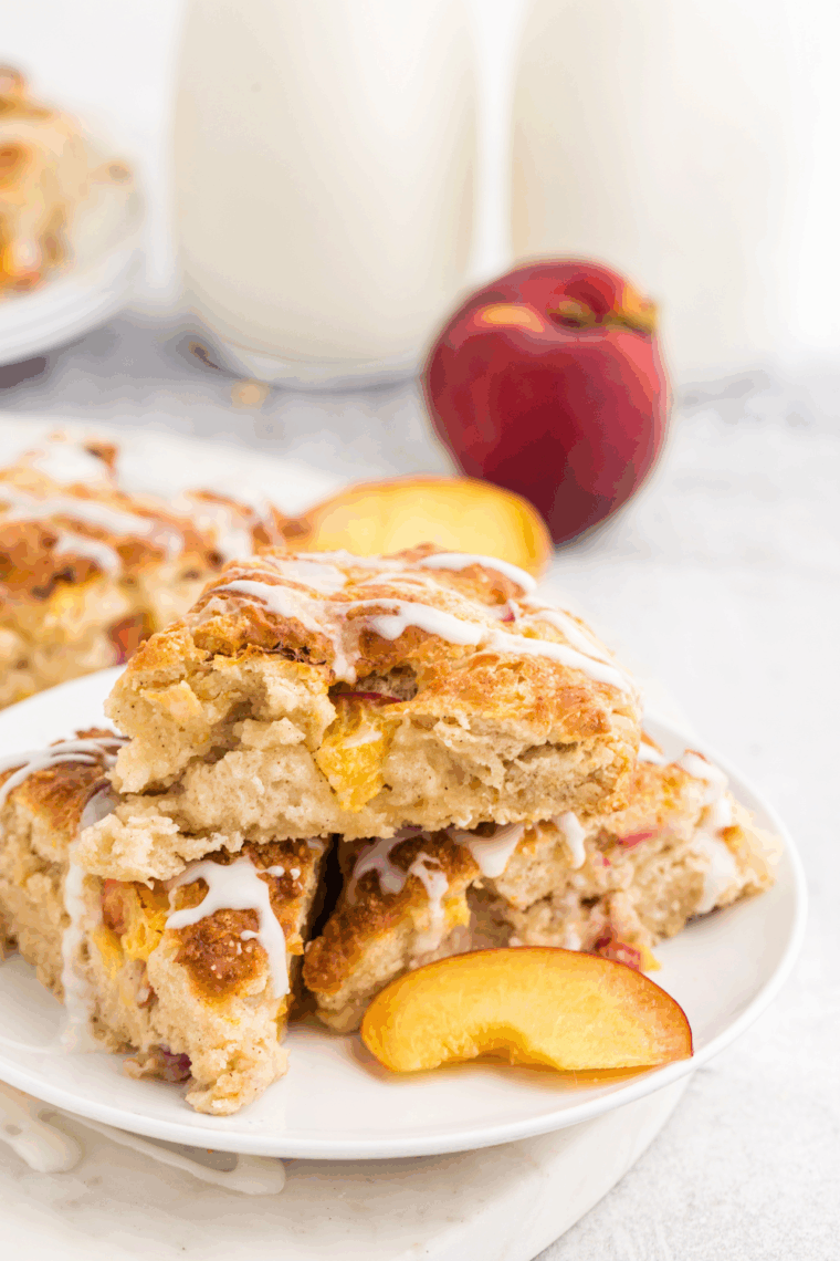 Stack of glazed air fryer peach scones served on a white plate