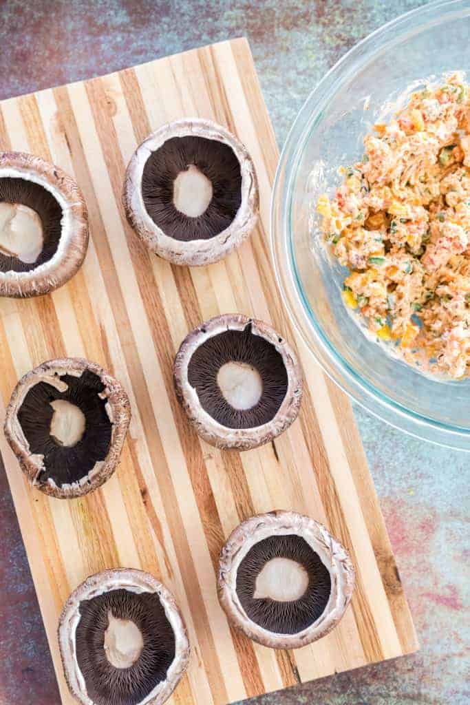 Raw Portobello Mushrooms on cutting board.