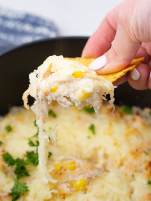 Plate of air fryer white chicken chili dip topped with melted cheese and cilantro, served with tortilla chips