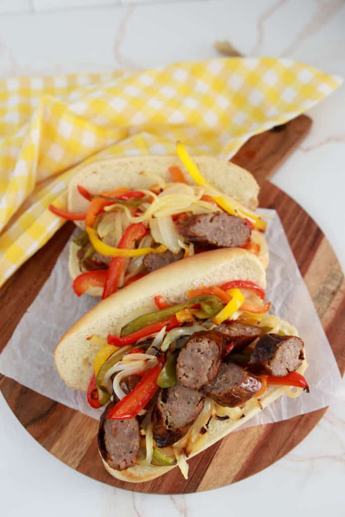 bratwurst and peppers on two rolls