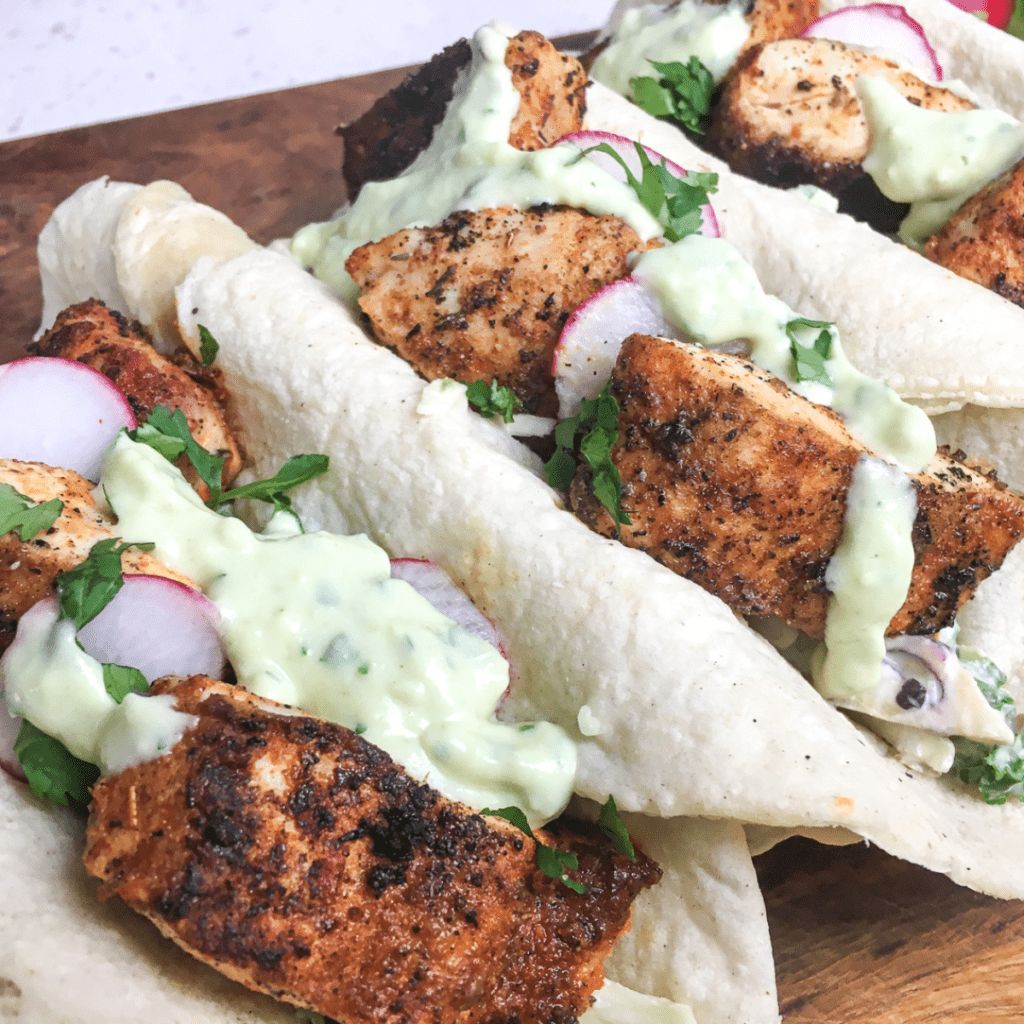 Air Fryer Blackened Cod fillets with a crispy, flavorful crust served on a plate with a side of vegetables.