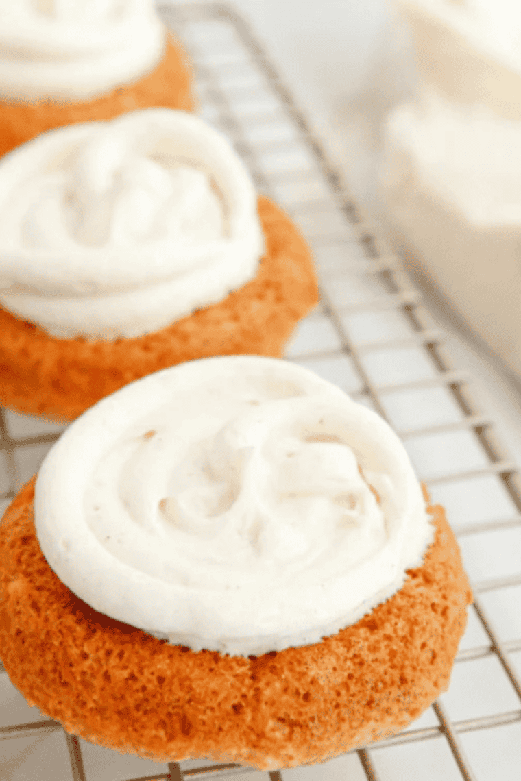 Freshly baked Air Fryer Apple Cinnamon Whoopie Pies stacked on a plate with creamy filling visible between soft cakes.