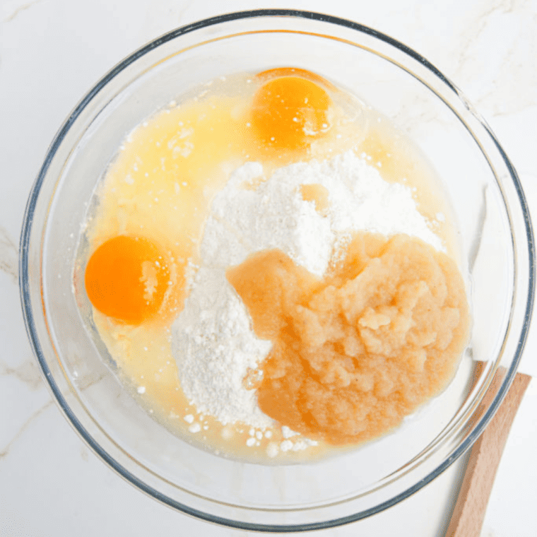Mixing yellow cake mix, eggs, and applesauce together in a large bowl until smooth.