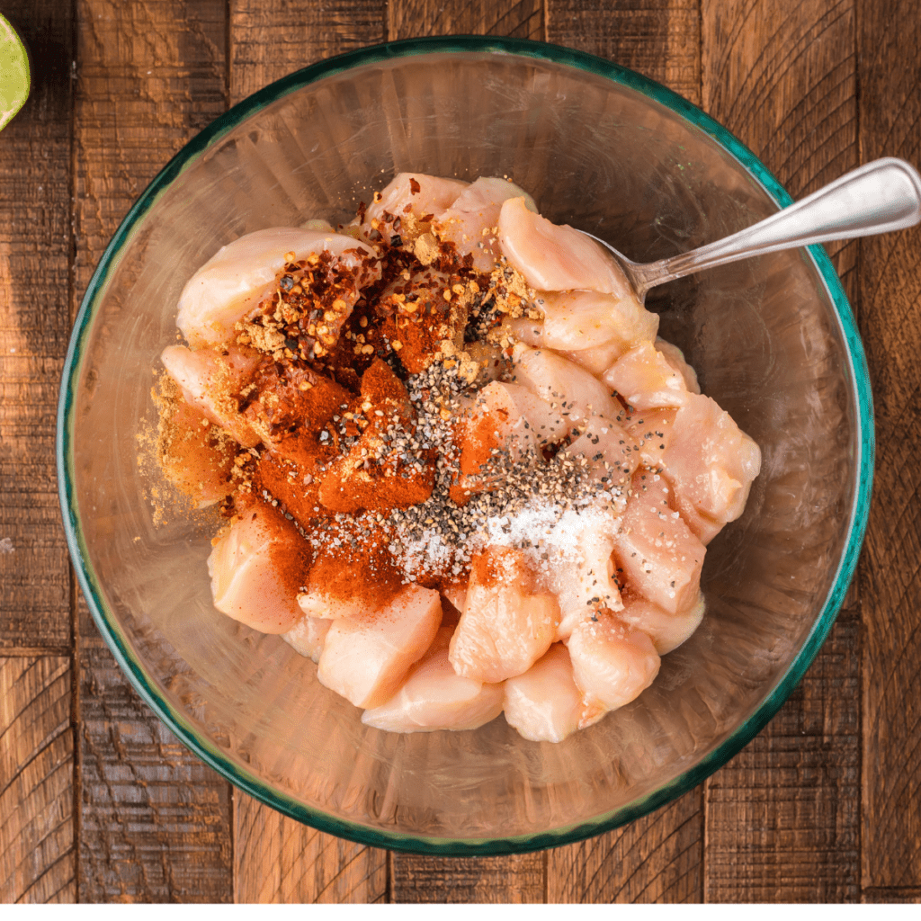 Raw chicken pieces and seasonings prepped for air fryer BBQ chicken bites.