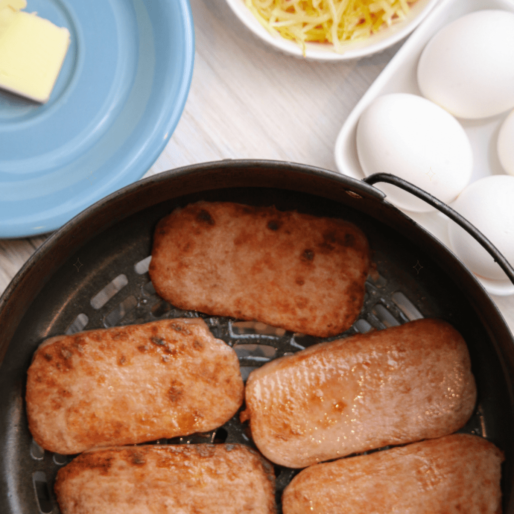 Cooking the spam in the air fryer basket.