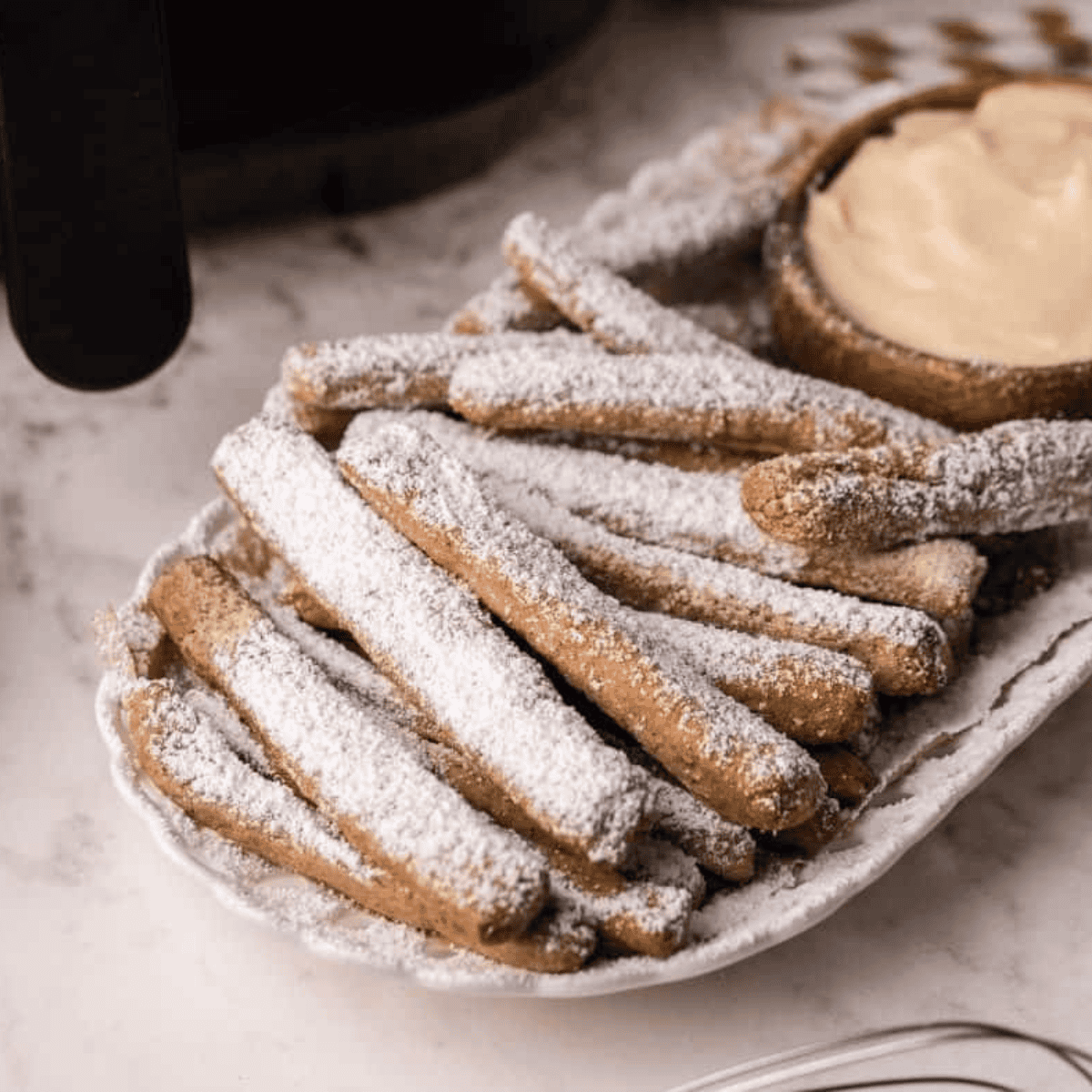 Air Fryer Funnel Cake Fries, golden and crispy, dusted with powdered sugar, ready to serve with a sweet dip.