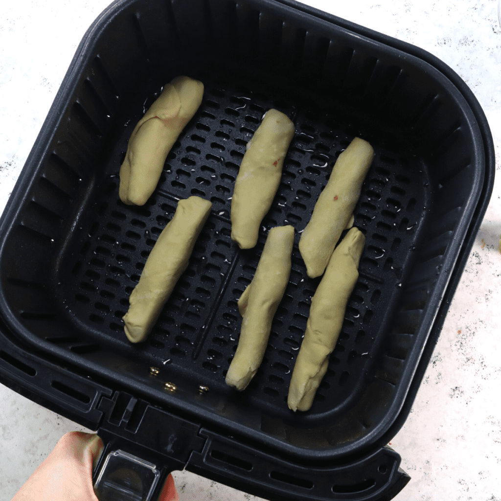 Nutella stuffed churros cooking in air fryer basket at 400°F until golden and crispy.