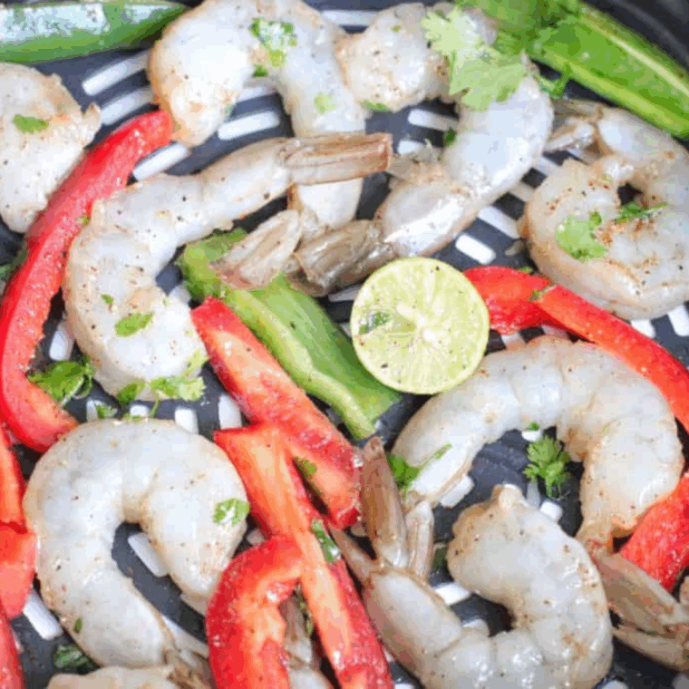 Shrimp, peppers, onions, and rice layered into a bowl and topped with cilantro and lime.