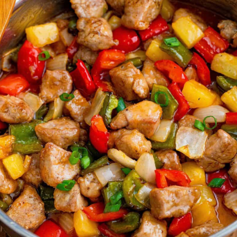 Air fryer sweet and sour pork served over steamed rice in a white bowl