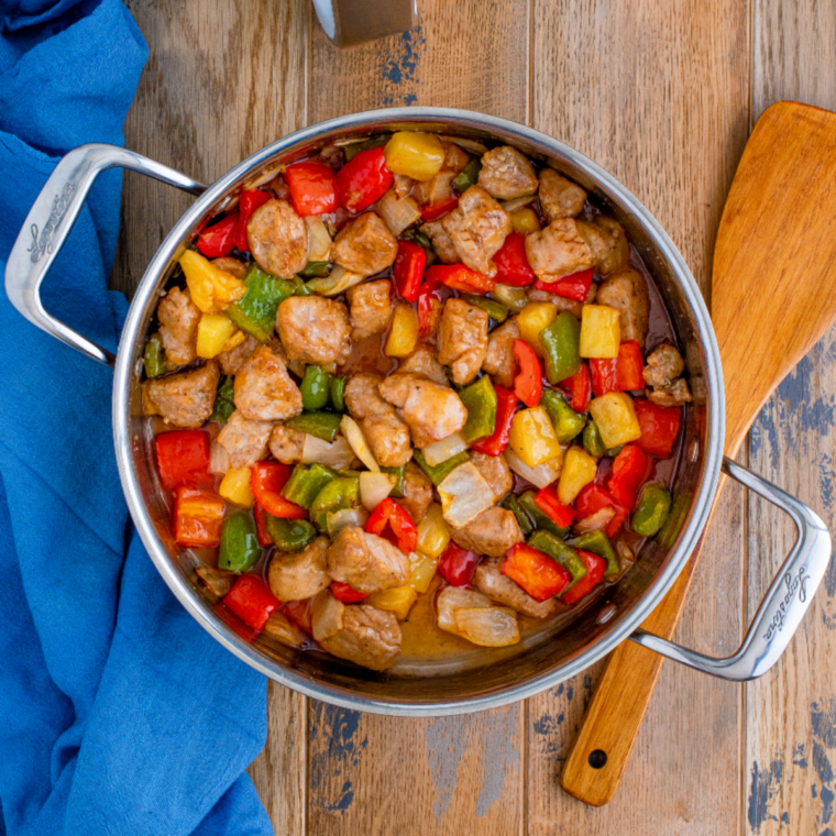 Close-up of crispy sweet and sour pork showing glossy sauce and pineapple