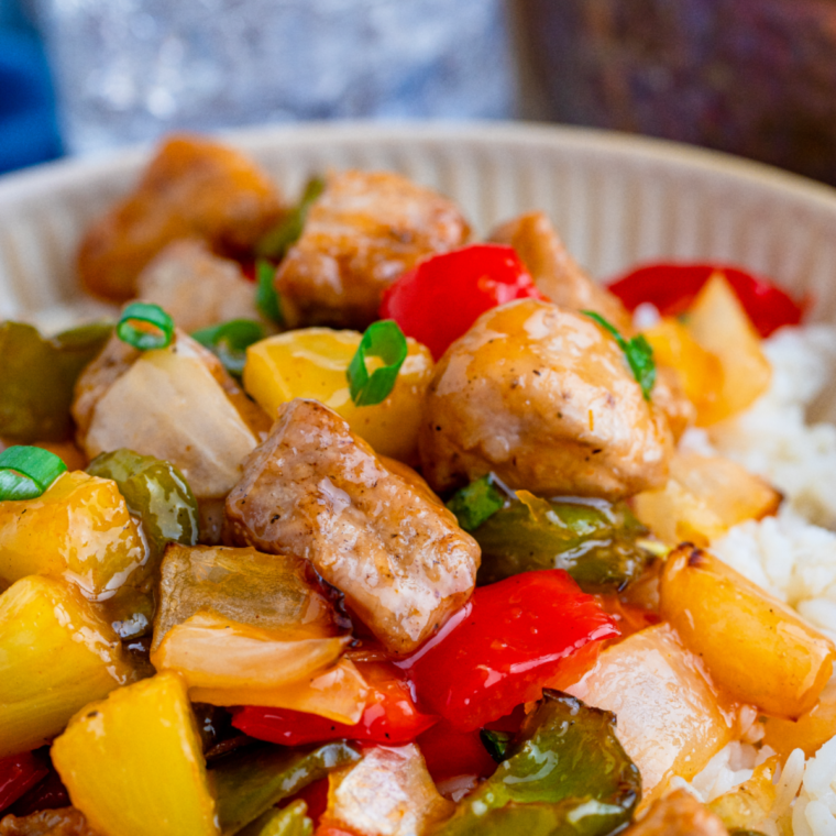 Air fryer sweet and sour pork served over white rice with pineapple and bell peppers