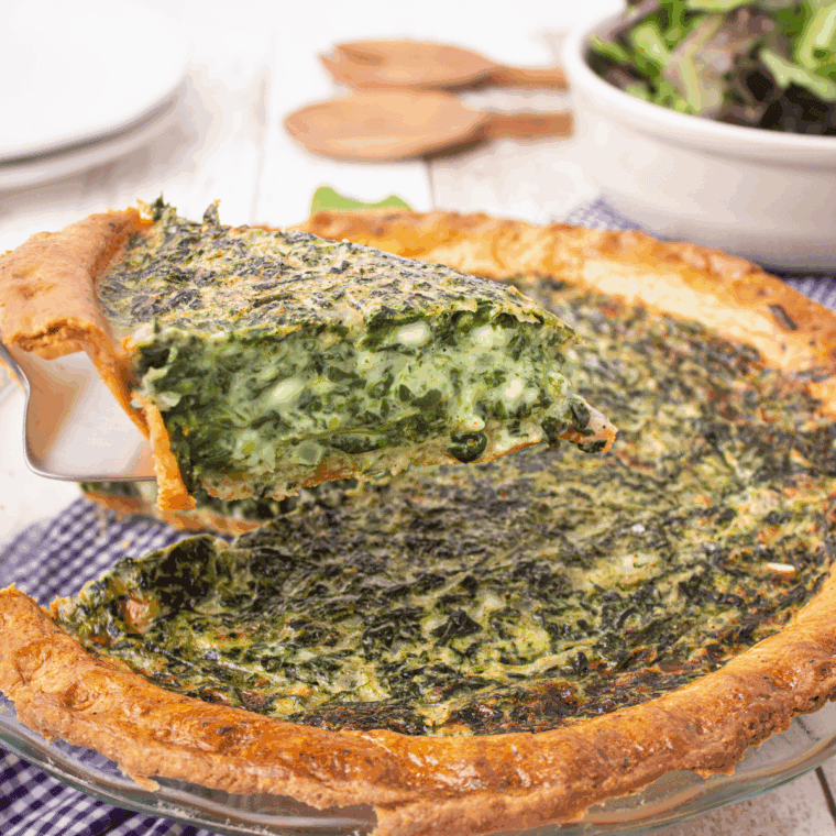 Slice of reheated quiche in air fryer basket with golden crust
