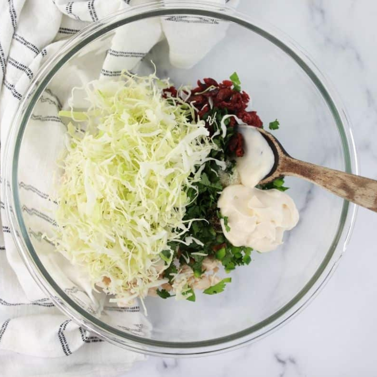 Mix shredded chicken, cilantro, jalapeno, salt, sugar, black pepper, cabbage, dried cranberries, mayonnaise, and rice wine vinegar in a large bowl for a flavorful egg roll filling.