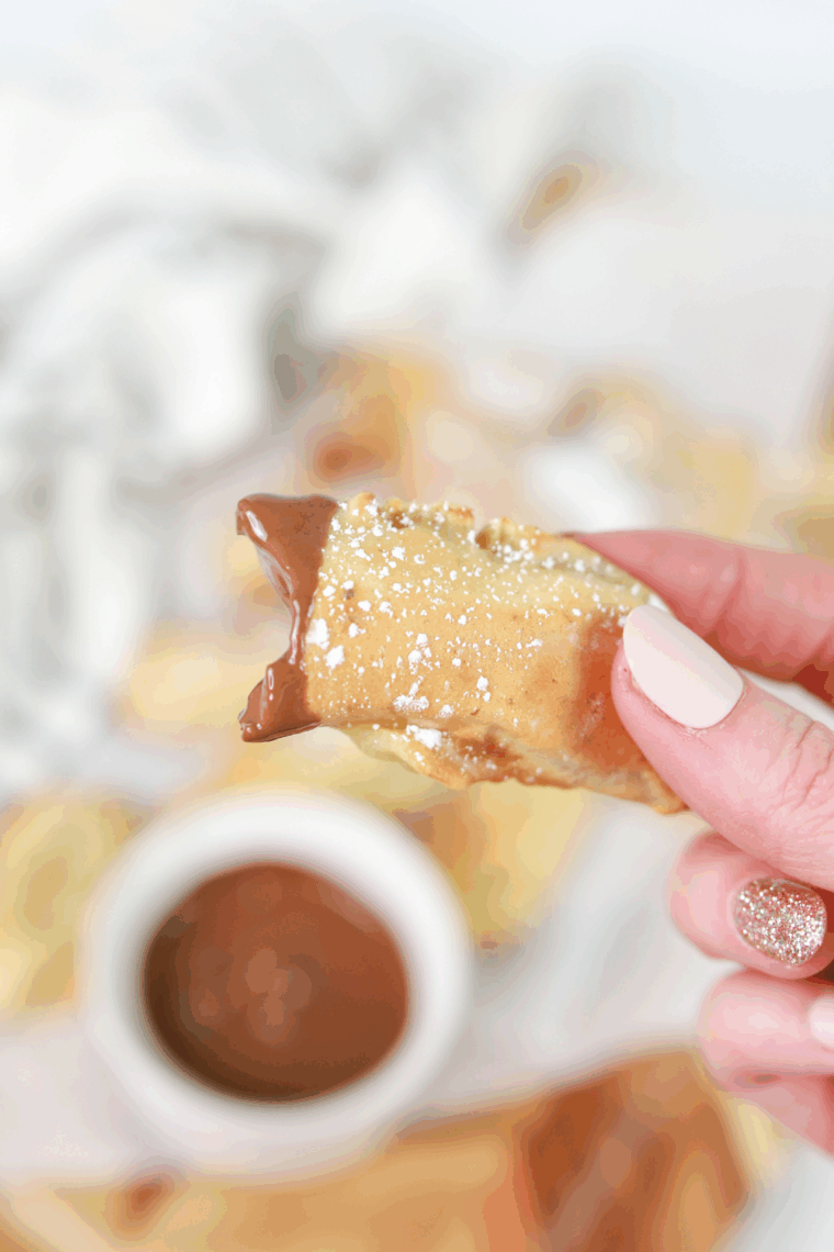 Golden air fryer banana pancake dippers arranged on a plate, crispy on the outside and soft inside, served with a small bowl of syrup for dipping.