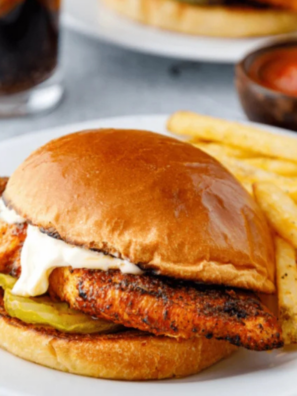 Air fryer blackened chicken breast sliced on a white plate, showing a dark spice crust and juicy interior