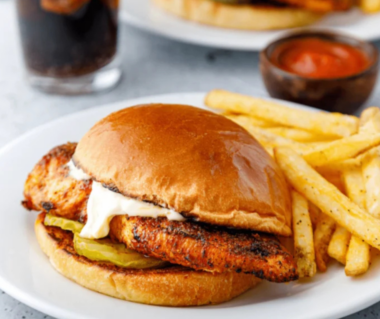 Air fryer blackened chicken breast sliced on a white plate, showing a dark spice crust and juicy interior