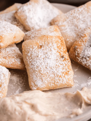 Copycat Marco's CinnaSquares piled on a white plate with vanilla icing for dipp