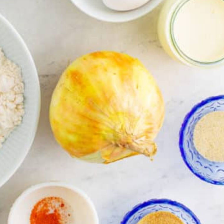 Whole uncut sweet Vidalia onion on a table, ready to make an air fryer bloomin' onion