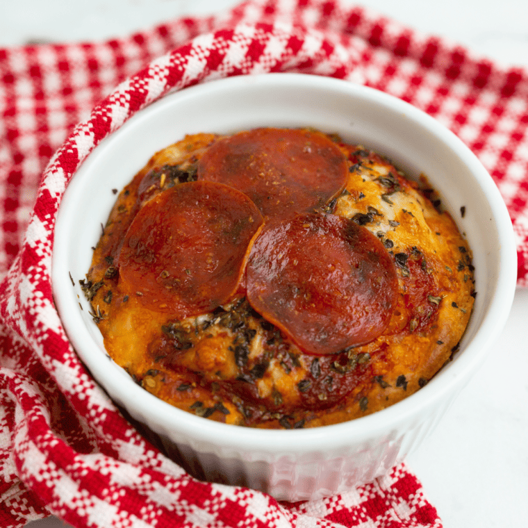Air fryer mug pizza in a mug with golden crust, melted cheese, and toppings