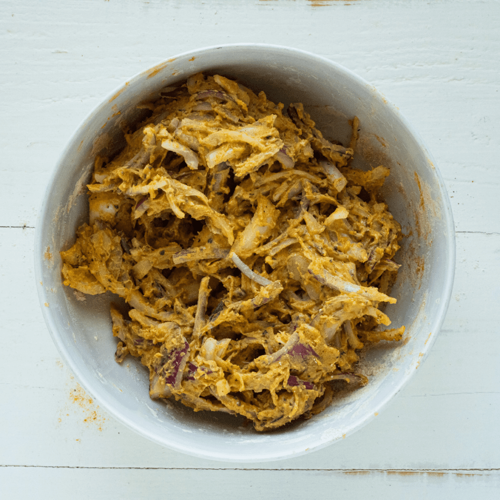 In a large mixing bowl, mix all of the ingredients for onion pakora.