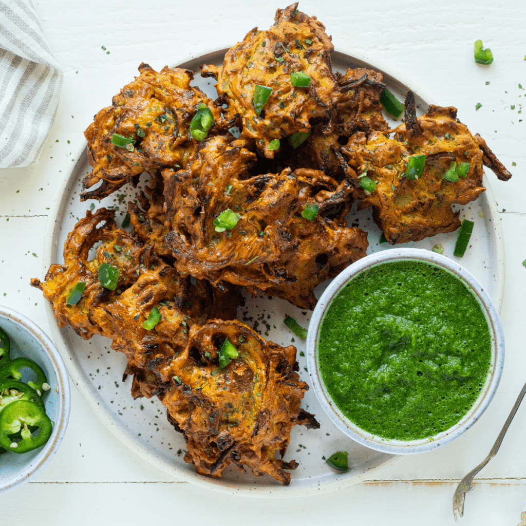 Onion Pakora cooked in air fryer basket on plate.