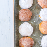 Air fryer pumpkin cheesecake donut holes rolled in cinnamon sugar stacked on a white plate