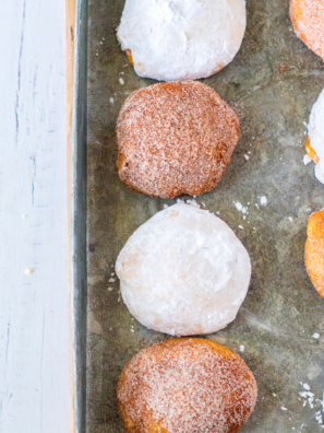 Air fryer pumpkin cheesecake donut holes rolled in cinnamon sugar stacked on a white plate