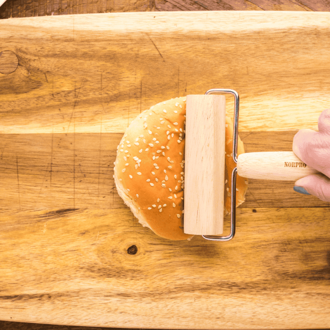 Flattened sesame seed buns placed on a metal taco stand, ready to be shaped into taco shells for Air Fryer Taco Burgers.