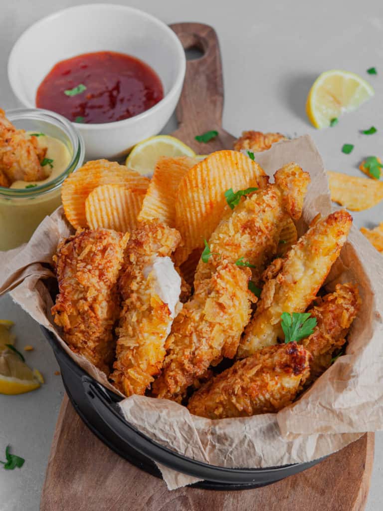 Crunchy potato chip crusted chicken tenders fresh from the air fryer, served with dipping sauce