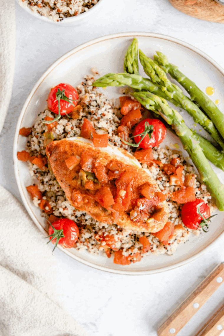 Air fryer Tuscan chicken with creamy sun-dried tomato garlic sauce and fresh herbs on a plate.