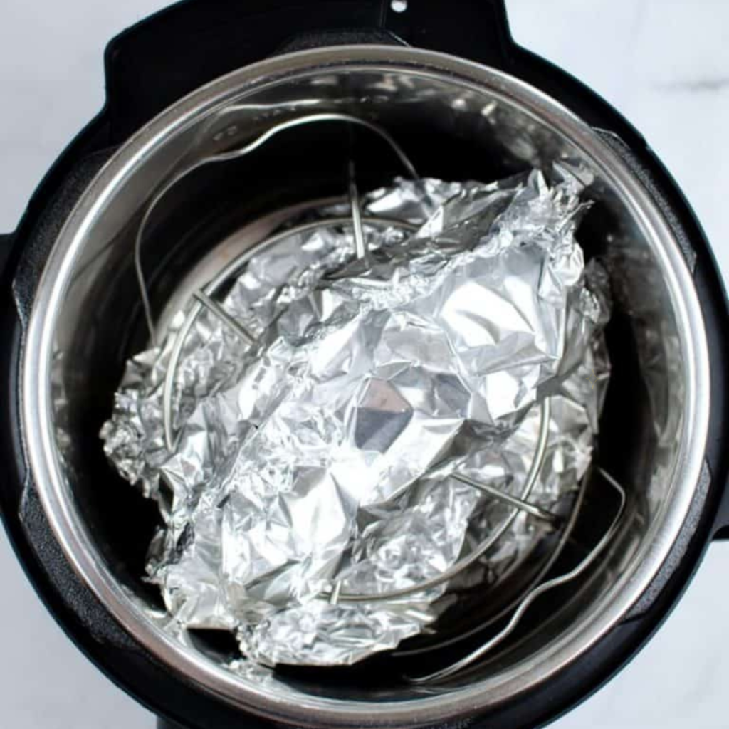 Cooking chicken in the Instant Pot for 18 minutes, then performing natural and quick release, checking temperature to ensure 165°F.