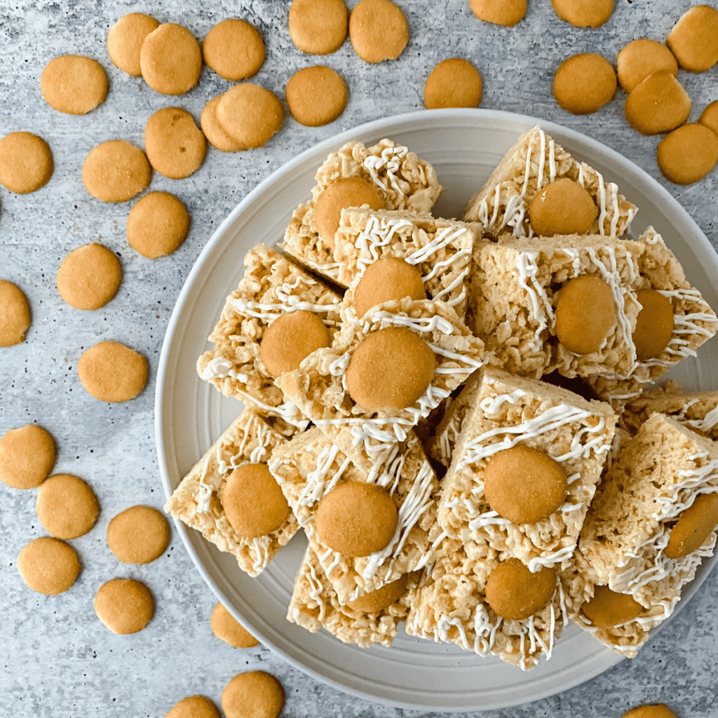 Banana pudding Rice Krispie treats stacked on a plate, creamy and golden