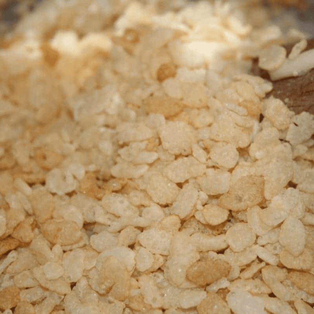 Slowly folding banana pudding mix and crushed wafers into the melted marshmallow rice cereal mixture until fully combined.
