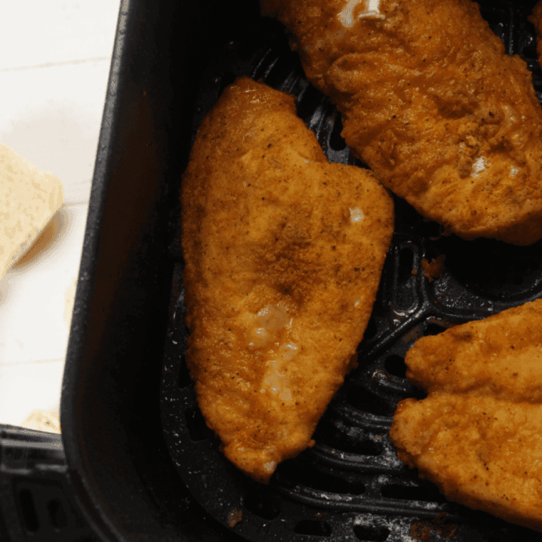 Cooked chicken breast in the air fryer basket.