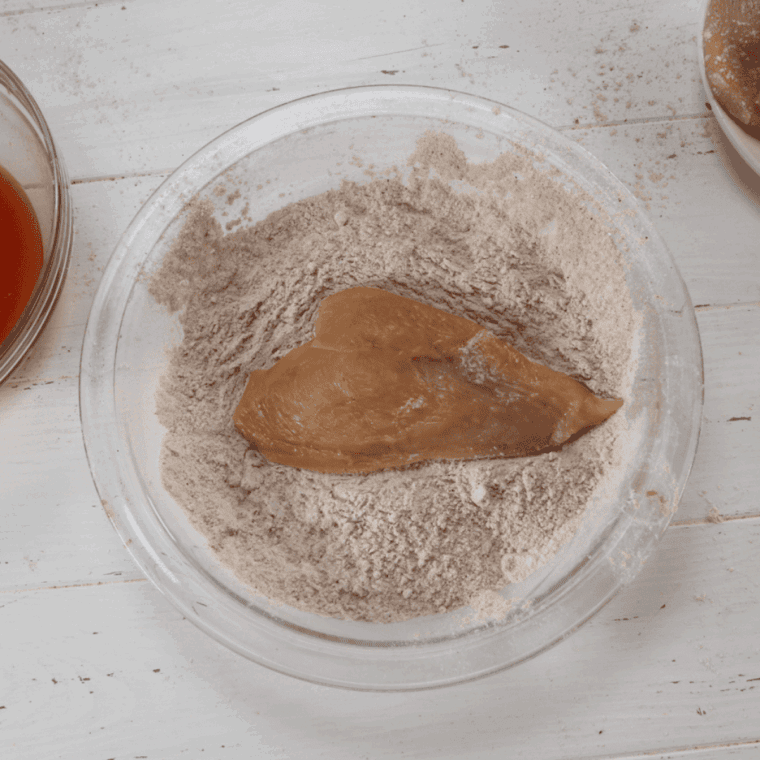 Dredge the chicken breast in the seasoned flour mixture.